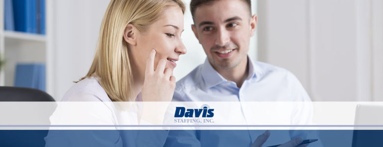 Man and woman employee sitting at computer